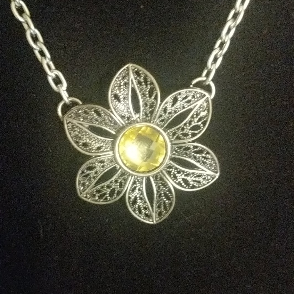 Intricate silver flower necklace with yellow jewel